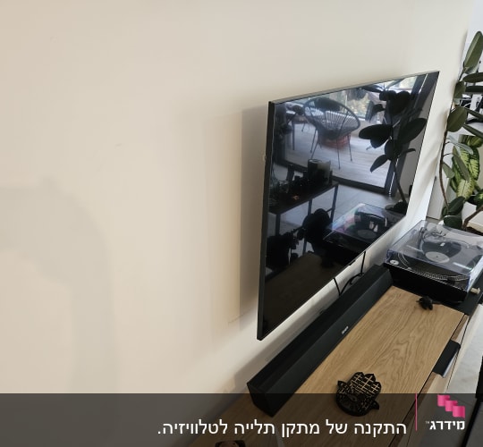 טלוויזיה תלויה על הקיר מעל מזנון עץ
